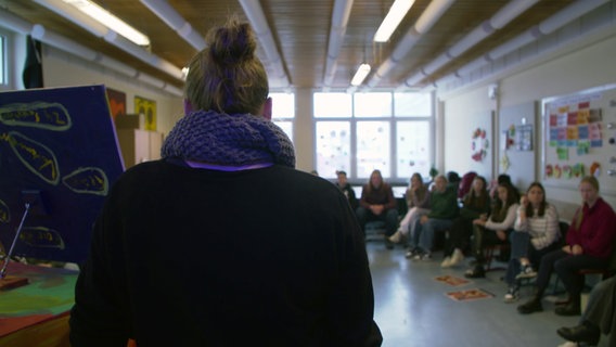 The back of a woman who is talking to young people.  © NDR Photo: NDR