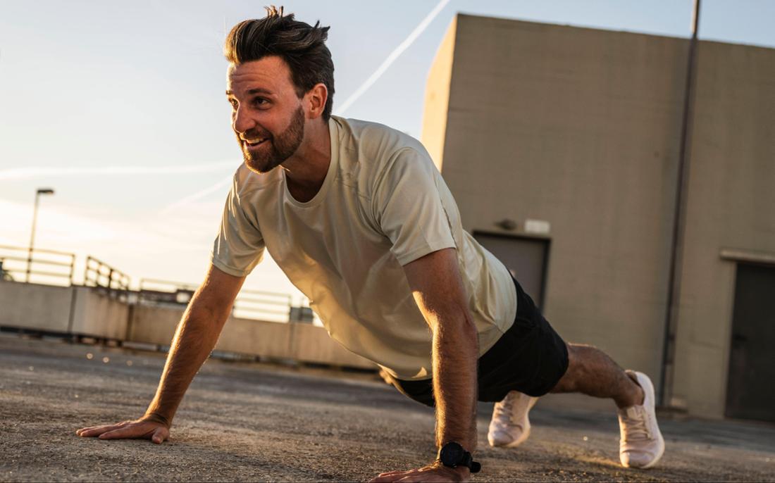 Fit man doing push-ups on the roof of a building